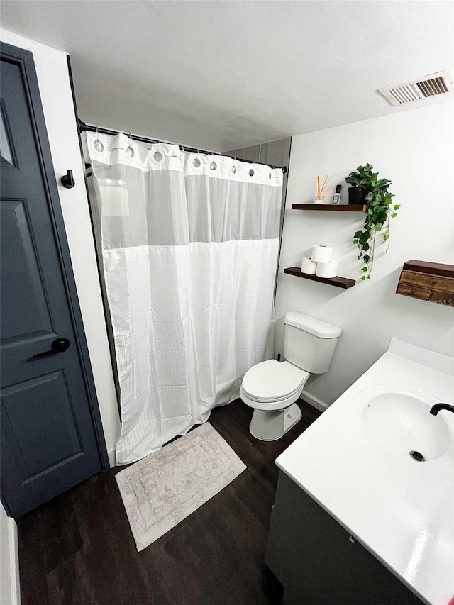 bathroom featuring vanity, hardwood / wood-style flooring, and toilet