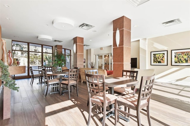 dining room with expansive windows and light hardwood / wood-style floors