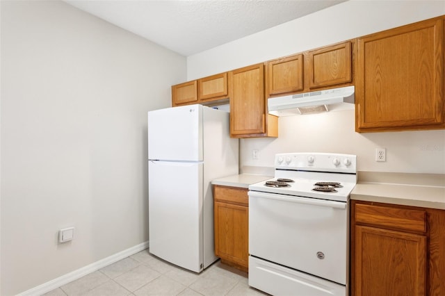 kitchen featuring light tile patterned floors, white appliances, and a textured ceiling