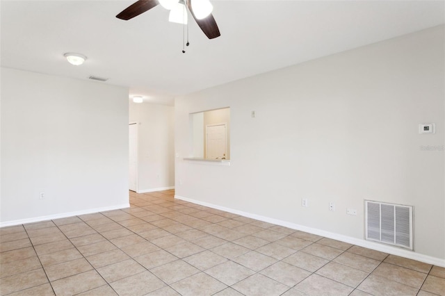 tiled empty room featuring ceiling fan