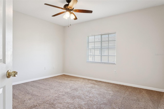 carpeted spare room featuring ceiling fan