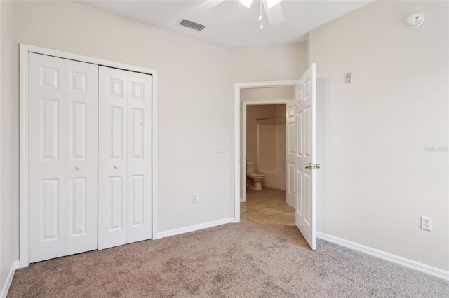 unfurnished bedroom with ceiling fan, a closet, and light colored carpet