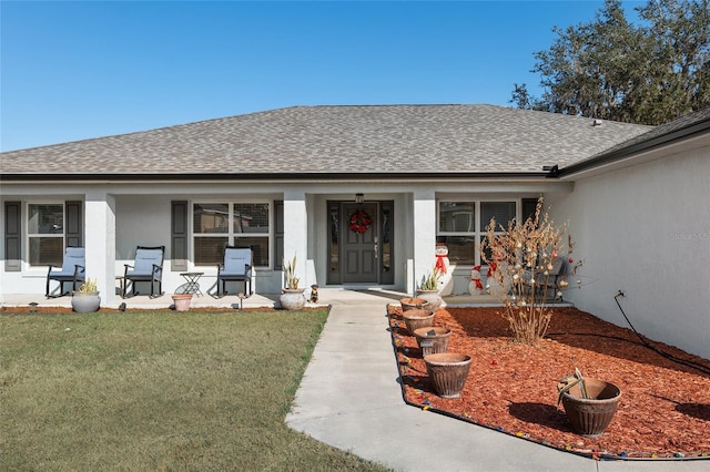 doorway to property with a lawn and a porch