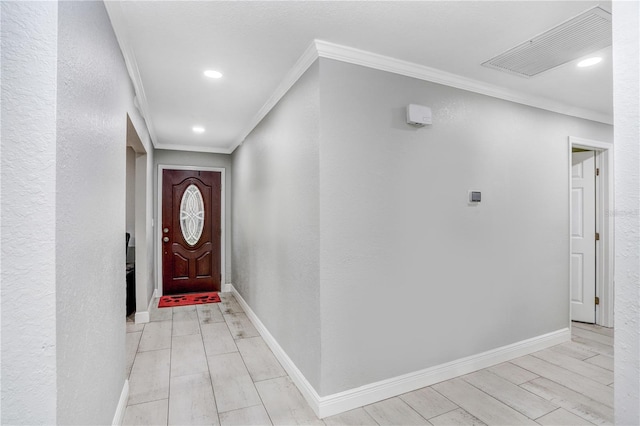 corridor with light hardwood / wood-style floors and ornamental molding