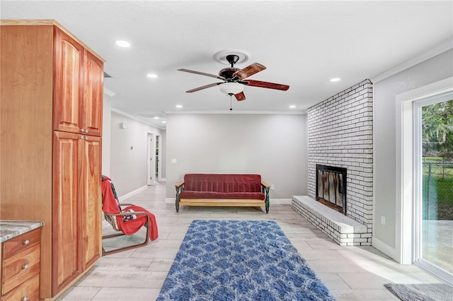 living room featuring crown molding, a fireplace, ceiling fan, and light wood-type flooring