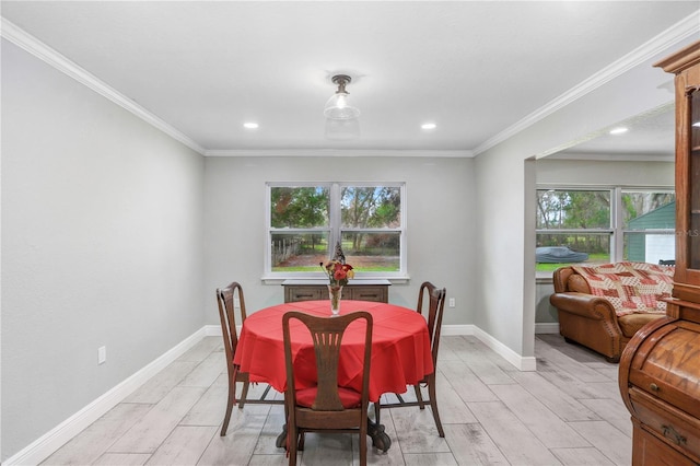 dining space with light hardwood / wood-style flooring, a wealth of natural light, and crown molding