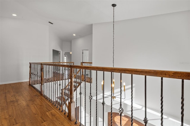 hall featuring an upstairs landing, recessed lighting, wood-type flooring, and baseboards