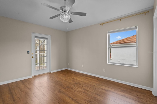 unfurnished room with a ceiling fan, hardwood / wood-style flooring, and baseboards