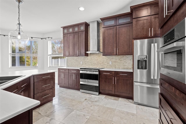 kitchen featuring stainless steel appliances, wall chimney exhaust hood, light countertops, and backsplash