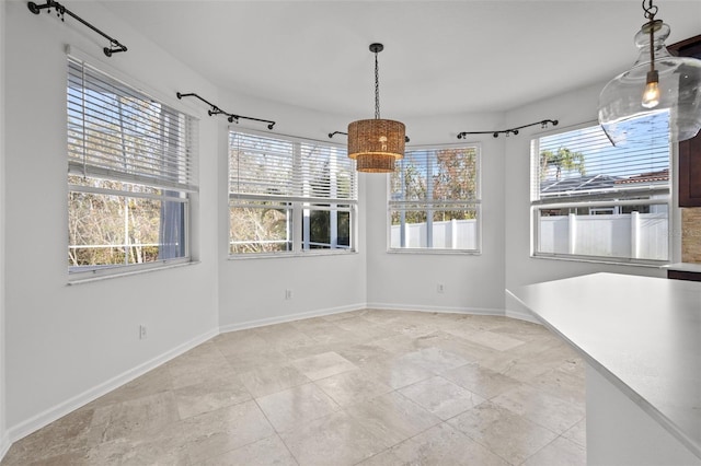 unfurnished dining area with baseboards