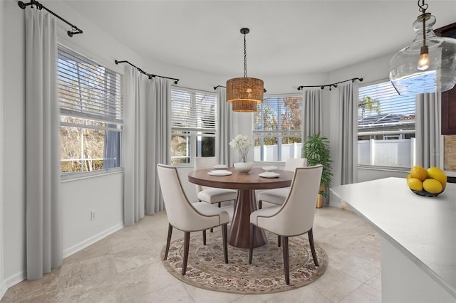 dining space featuring a healthy amount of sunlight and baseboards