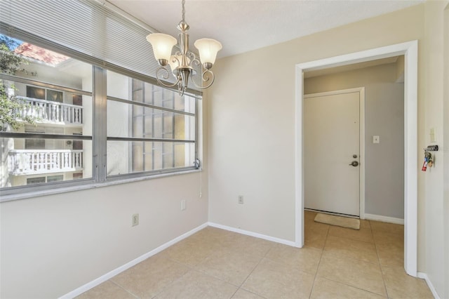 tiled empty room with a notable chandelier