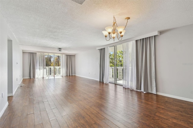 unfurnished room with ceiling fan with notable chandelier, a textured ceiling, and dark hardwood / wood-style flooring