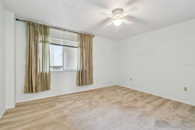 carpeted empty room featuring ceiling fan and a textured ceiling