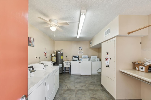 clothes washing area featuring washing machine and dryer, electric water heater, a textured ceiling, and ceiling fan