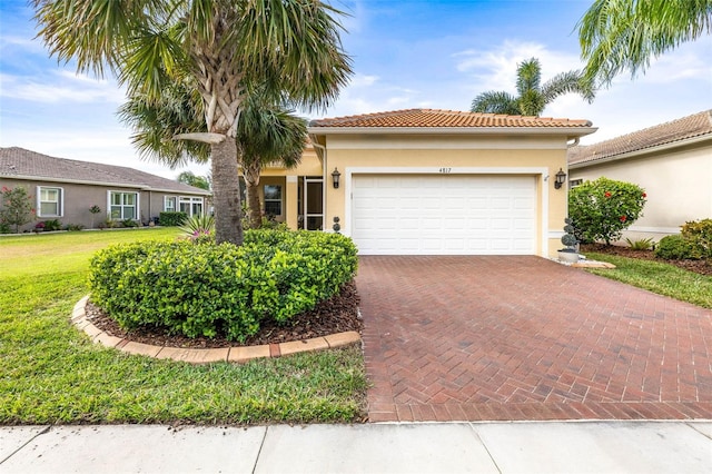 mediterranean / spanish-style home featuring a garage and a front lawn