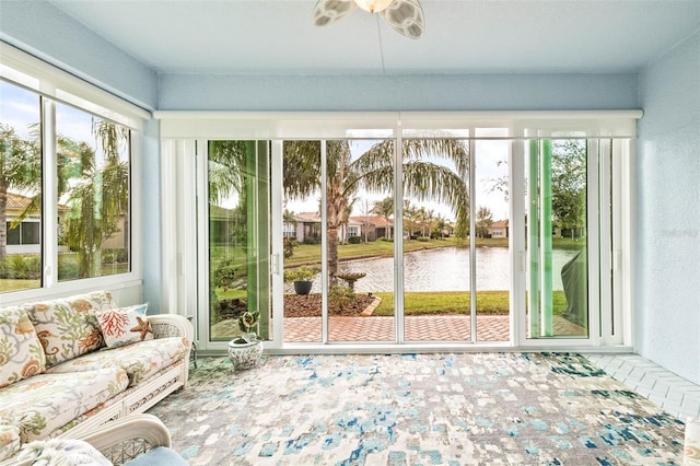 unfurnished sunroom with a water view and ceiling fan