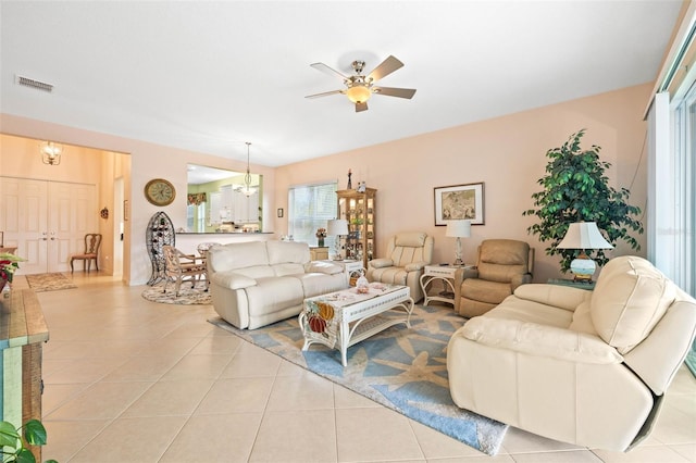 living room with ceiling fan with notable chandelier and light tile patterned flooring