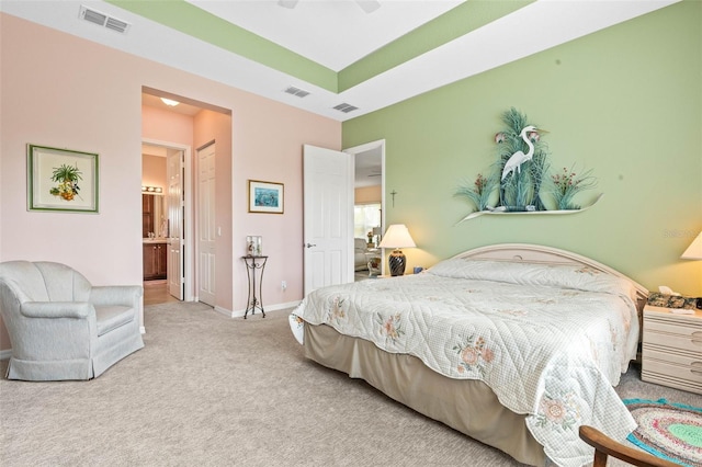 carpeted bedroom featuring ceiling fan and ensuite bath