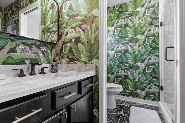 bathroom with vanity, toilet, and a shower with shower door