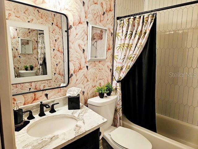 full bathroom featuring vanity, toilet, and shower / bath combo with shower curtain