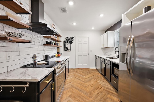 kitchen with decorative backsplash, stainless steel appliances, sink, wall chimney range hood, and white cabinetry