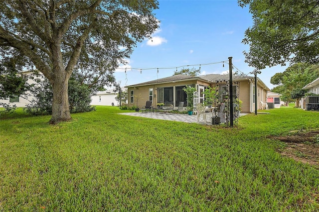 rear view of house featuring a lawn and a sunroom