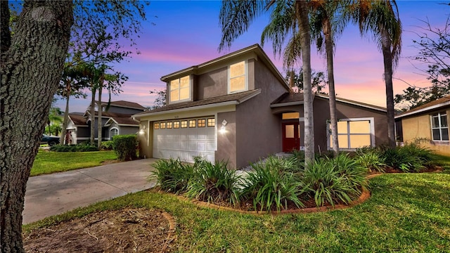 front facade with a garage and a lawn