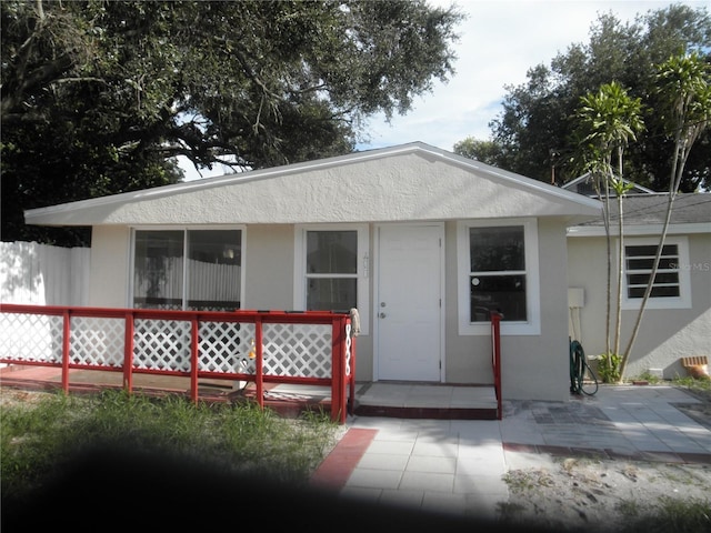 view of front facade featuring fence and stucco siding