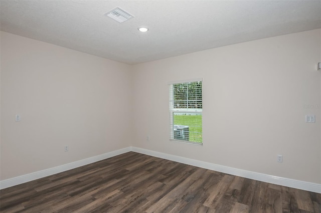 spare room with dark wood-type flooring