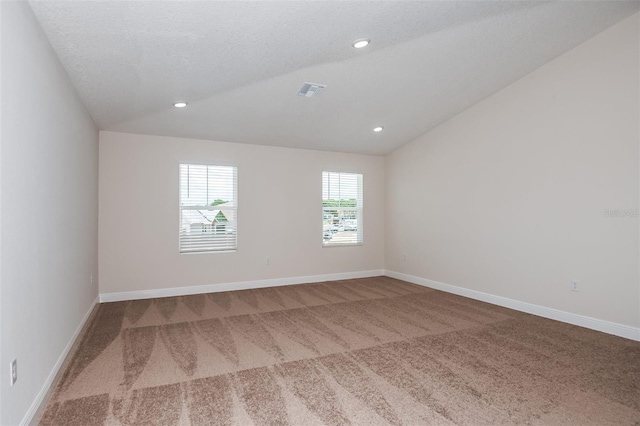 carpeted spare room with lofted ceiling and a textured ceiling