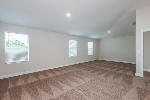 carpeted spare room featuring lofted ceiling