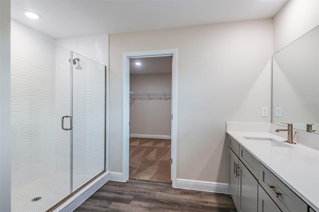 bathroom with hardwood / wood-style flooring, vanity, and an enclosed shower