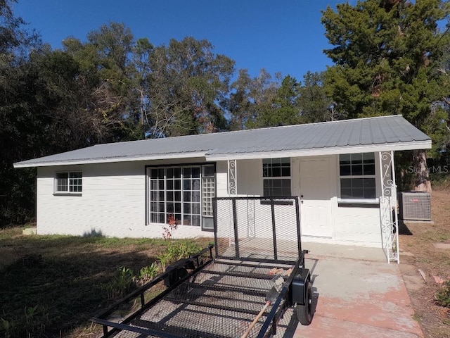 ranch-style house featuring central air condition unit and a porch