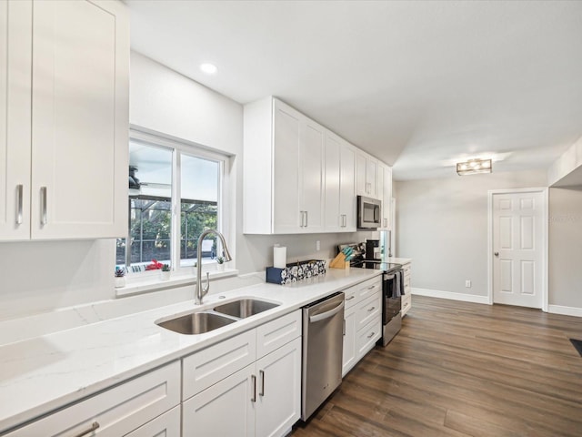 kitchen featuring appliances with stainless steel finishes, dark hardwood / wood-style flooring, light stone counters, sink, and white cabinets