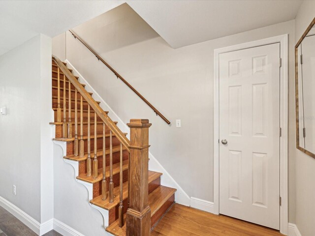 stairs featuring hardwood / wood-style floors