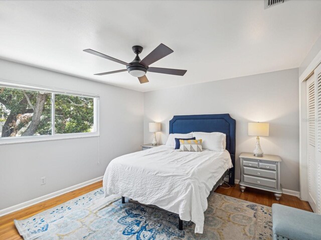 bedroom featuring ceiling fan, dark hardwood / wood-style flooring, and a closet