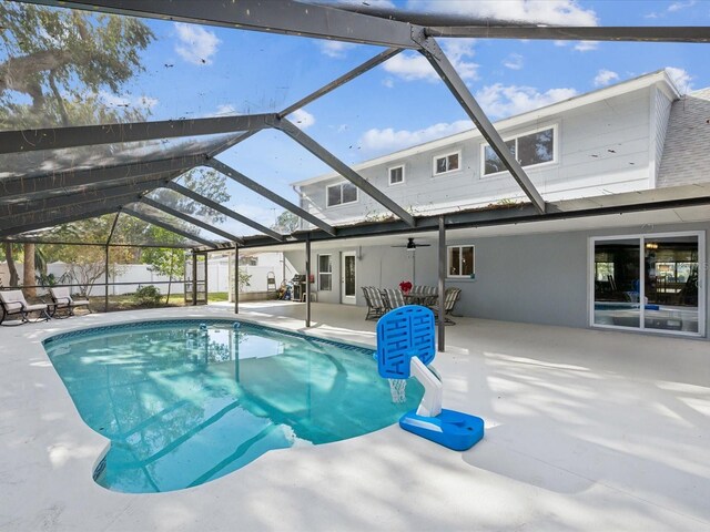 view of pool with glass enclosure and a patio area