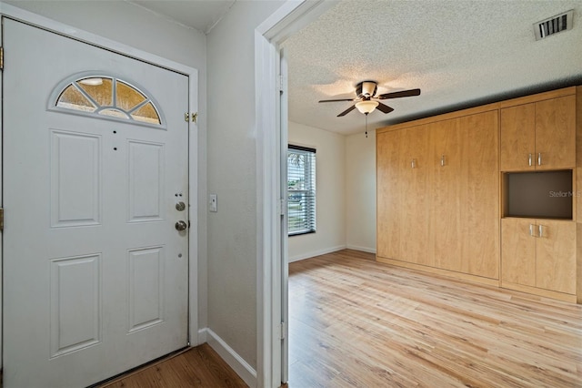 entryway featuring ceiling fan, a textured ceiling, and light wood-type flooring