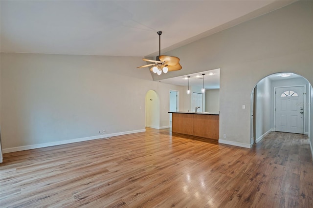 unfurnished living room with light wood-type flooring, ceiling fan, and lofted ceiling