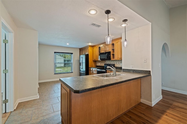 kitchen featuring black appliances, sink, backsplash, hanging light fixtures, and kitchen peninsula