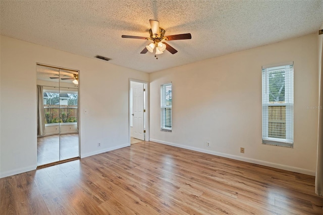 unfurnished room featuring a textured ceiling, light hardwood / wood-style flooring, and ceiling fan