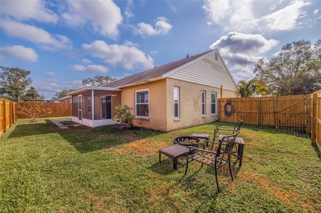 rear view of house with a sunroom and a lawn