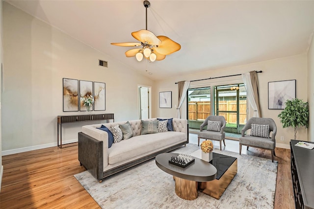 living room featuring vaulted ceiling, ceiling fan, and light hardwood / wood-style flooring