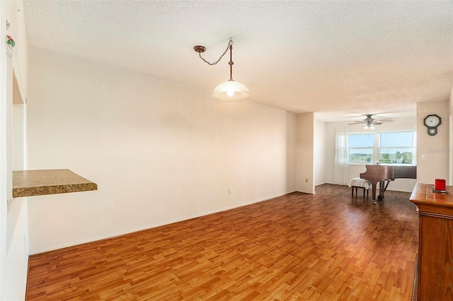 unfurnished living room featuring hardwood / wood-style floors, a textured ceiling, and ceiling fan