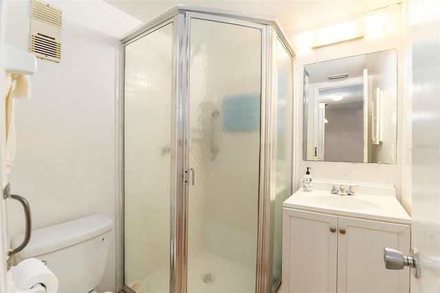 bathroom with vanity, a shower with shower door, and toilet