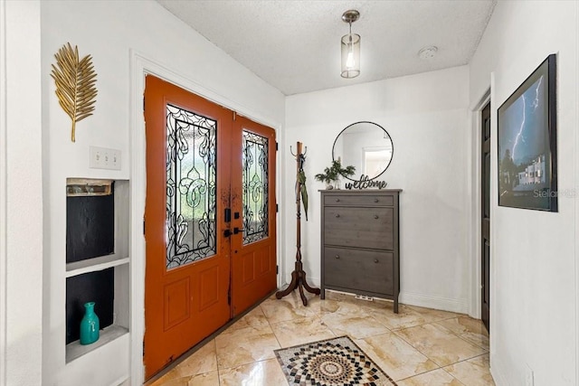 entrance foyer featuring french doors and a textured ceiling