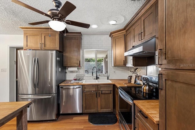 kitchen featuring sink, light hardwood / wood-style flooring, ceiling fan, a textured ceiling, and stainless steel appliances