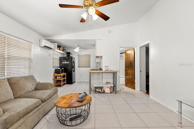 living room with ceiling fan, sink, an AC wall unit, lofted ceiling, and light tile patterned floors