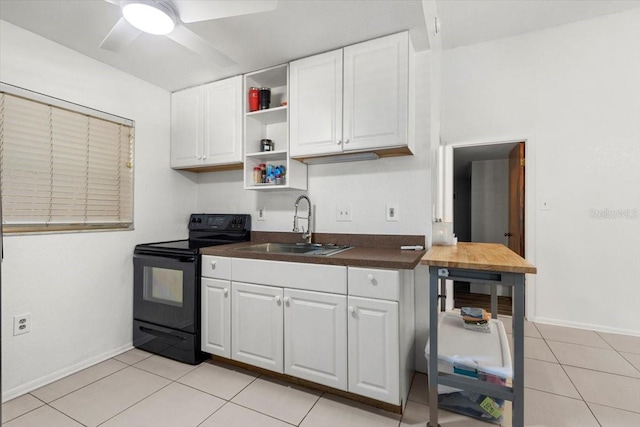 kitchen featuring ceiling fan, sink, light tile patterned floors, white cabinets, and black / electric stove